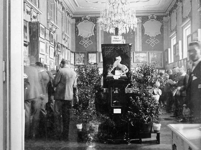 Historikus aukciós csarnok csillárral és falra akasztott festményekkel
